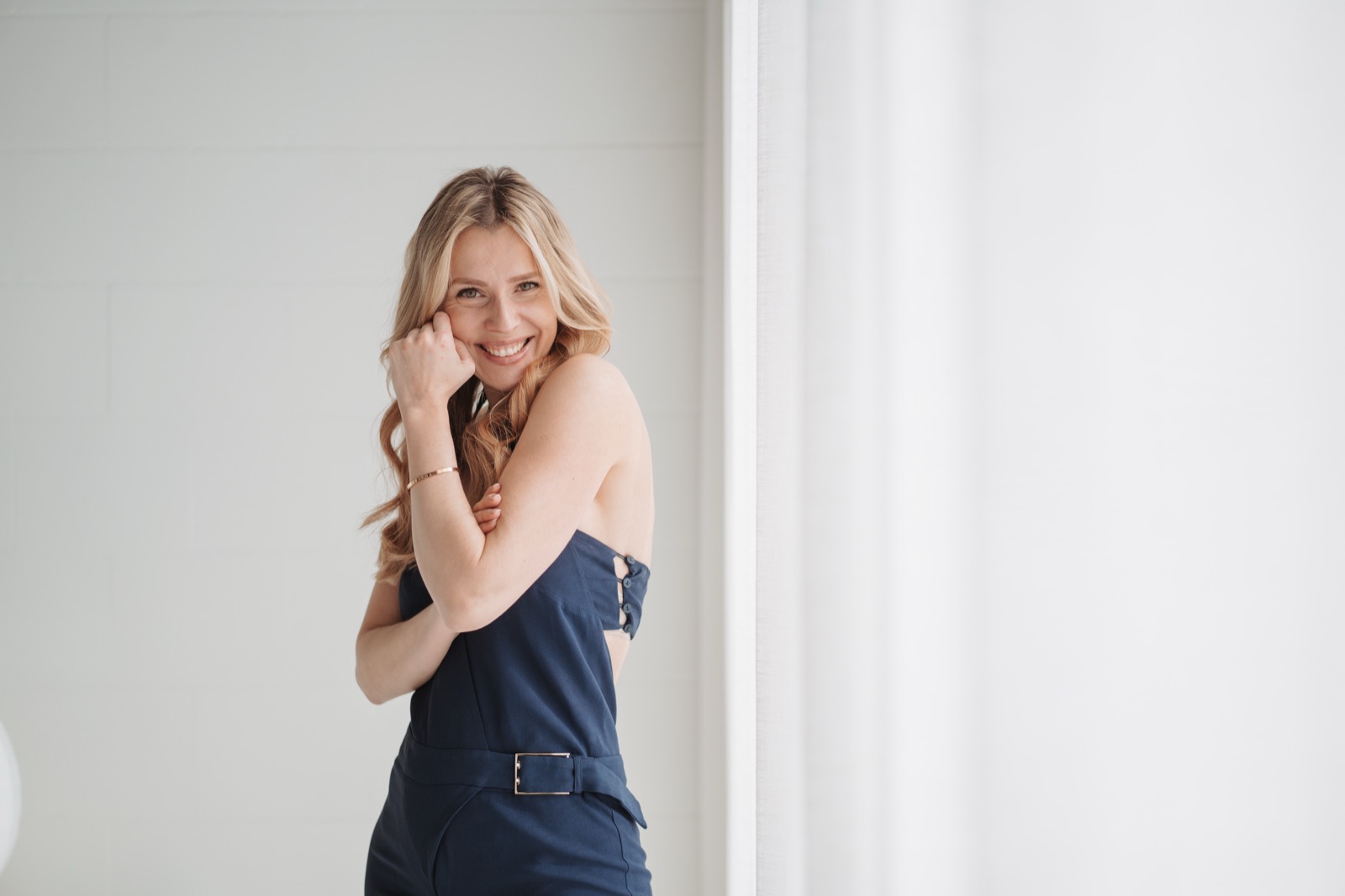 Lana Kern lacht, an ein Fenster gelehnt